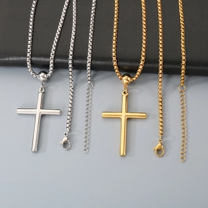 Close-up of gold and silver stainless steel cross pendants with venetian chains
