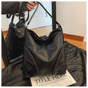 Detail of a black large capacity PU leather tote bag with soft lychee texture finish