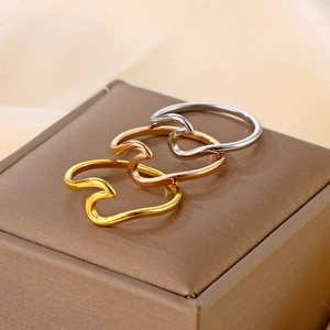 Minimalist titanium steel wave rings in gold, rose gold, and silver finishes stacked