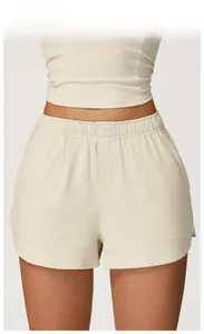 Détail de la taille élastique haute et du tissu doux couleur abricot sur le short