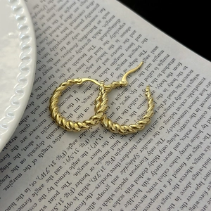 Macro detail of French vintage twisted rope hoop earrings in 14K gold plated finish