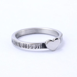 Minimalist silver stainless steel heart ring with vertical textured finish on white background