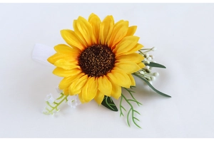 Close-up of artificial sunflower boutonniere with green leaves and white ribbon
