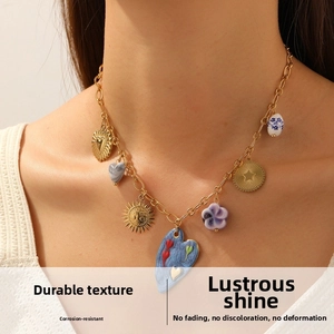 Detail of multi-element gold-plated stainless steel necklace on model showing enamel charms