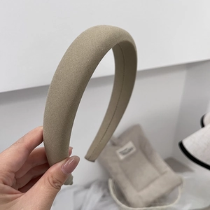 Detailed view of khaki sponge headband featuring premium woven fabric texture and wide design