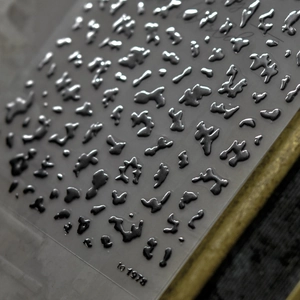 Detailed view of silver 3D teardrop laser nail art stickers with metallic texture