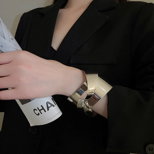 Macro shot of silver wide multi-layer knotted cuff bracelet on model's wrist