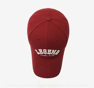Detailed top view of a dark red baseball cap with white 3D embroidery on cotton twill