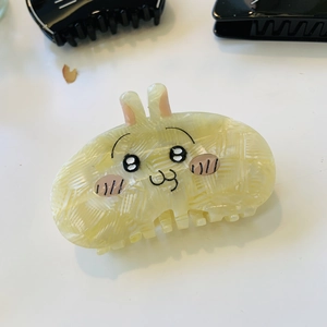 Detail view of a cute yellow rabbit claw clip made from premium acetate material