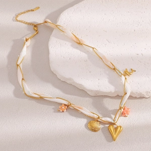 Detailopname van 18K vergulde lintketting met schelp- en hartvormige hangertjes