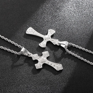 Detailed view of two vintage silver cross pendants with heart and floral engravings