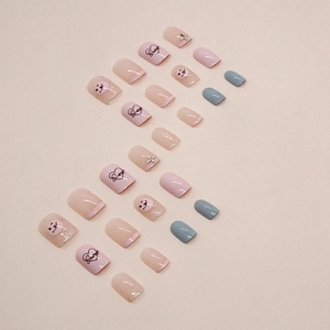Sweet pink heart press-on nails with smile patterns and 'Sweet' lettering design