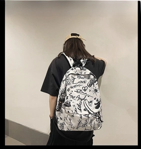 Close-up of a white street style canvas backpack with black graffiti love patterns