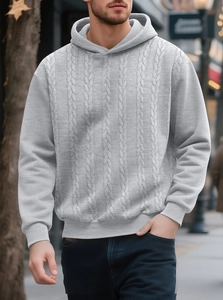 Detail of the chunky knit texture and ribbed cuffs on a men's light grey hooded sweatshirt
