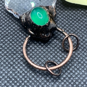 Macro shot of vintage pendant with green agate stone and red copper metal rings