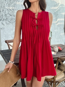 Detail of red sleeveless pleated mini dress featuring a lace-up hollow front design