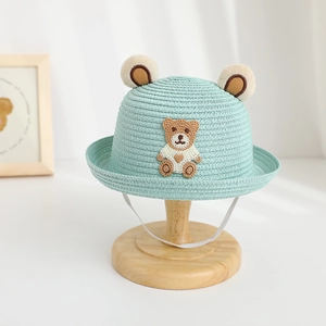 Detail of mint green straw hat with cute plush bear ears and windproof strap for kids