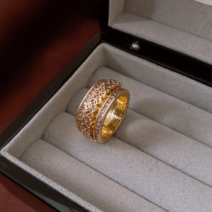 Close-up of gold-plated tiger eye ring with hollow lattice design and inlaid zircons