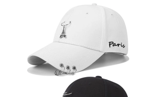 Close-up of Eiffel Tower pendant and Paris embroidery on a stylish white baseball cap