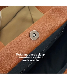 Macro detail of high-quality metal magnetic clasp and leather texture on a brown tote bag