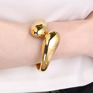 Minimalist irregular gold crossover open bangle with polished fluid teardrop design for women