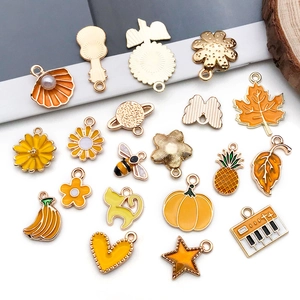 Flat lay of diverse yellow and orange alloy charms for DIY jewelry making