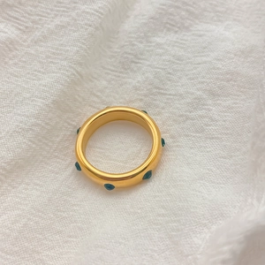 Vue détaillée d'une bague en titane plaqué or ornée de cristaux verts émeraude sertis
