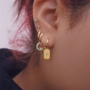Detailed close-up of celestial gold earrings set with blue opal and sparkling crystals