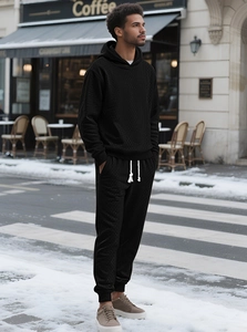 Detail of black textured waffle knit tracksuit with hoodie and matching joggers on model