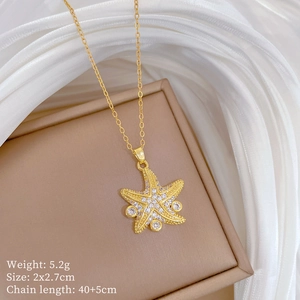 Macro detail of gold starfish necklace with cubic zirconia and sizing specifications