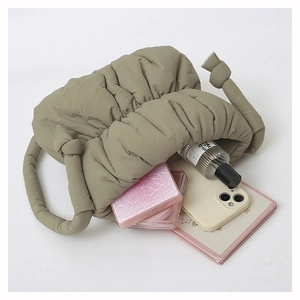 Spacious green quilted bucket bag showing interior storage for phone and cosmetics