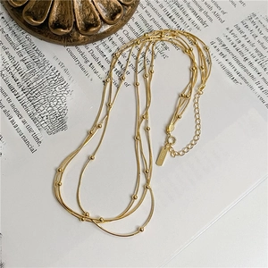 Detail of S925 sterling silver triple layer snake chain necklace with gold finish