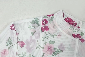 Detailed close-up of pink floral print on semi-transparent white mesh fabric