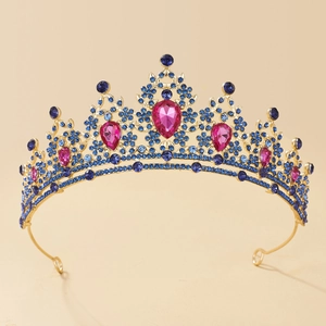 Macro detail of golden bridal crown featuring blue rhinestones and pink teardrop gems