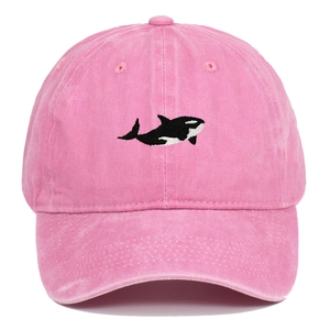 Washed pink cotton baseball cap with embroidered orca on a white background