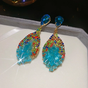 Detailed close-up of Bohemian leaf-shaped earrings with colorful crystals on velvet