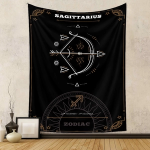 Detail view of black Sagittarius zodiac tapestry with gold print hanging on a wall