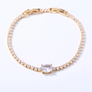 Detail of gold tennis bracelet with square zircons and an oval clear center stone