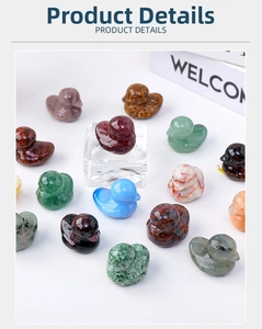 Close-up of hand-carved natural red jasper duck crystal figurine on acrylic stand