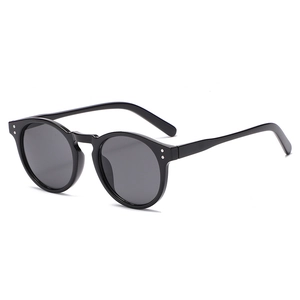 Retro black round sunglasses with silver rivets and dark polarized lenses on white background