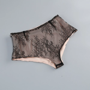 Detail eines schwarzen Spitzenmieders mit nudefarbenem Futter und floralem Lochmuster