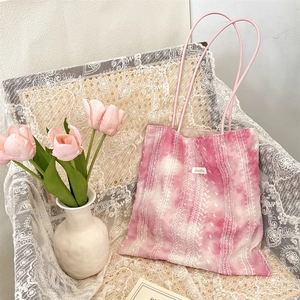 Close-up of pink tie-dye tote bag with lace patterns and Sorokka brand tag on the front