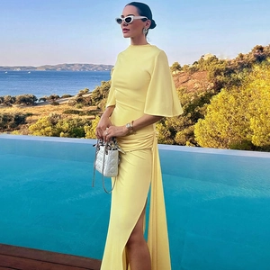Detail of elegant yellow backless long dress with flowing ribbons and side high slit