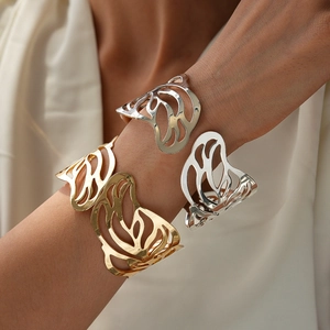 Exaggerated hollow butterfly wing cuff bracelets in gold and silver finish on model's arm