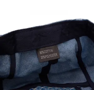 Detail of the inner care label on the blue denim beret showing material composition