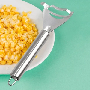 Macro shot of stainless steel corn peeler with serrated edge on white plate