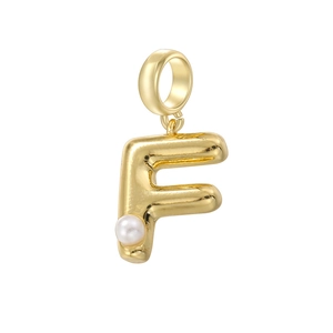 Détail d'un pendentif lettre F dorée avec finition polie et accent de perle blanche