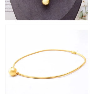 Detail showing high-polish gold ball pendant on a sleek snake chain necklace for women