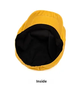Detail of yellow newsboy cap showing black fabric lining and neat stitching inside