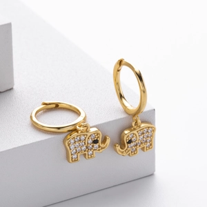Macro detail of gold elephant hoop earrings with shimmering pavé zircon stones